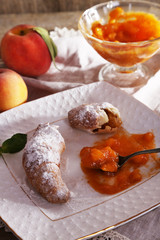 tasty apricot jam and croissants on wooden table