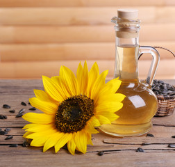Sunflower with seeds and oil on wooden background