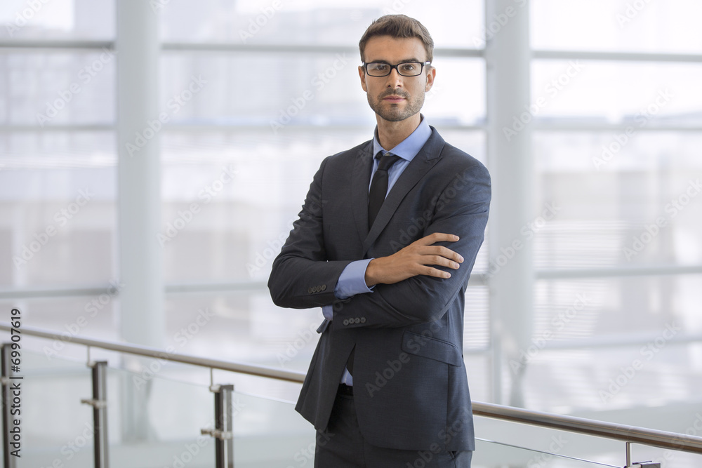 Wall mural portrait of a handsome young businessman wearing glasses