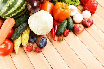 Fresh organic fruits and vegetables on wooden background