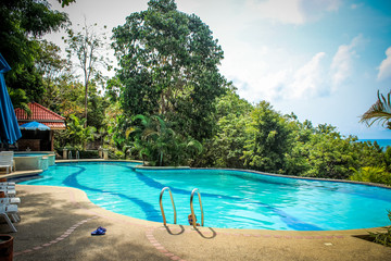 Fototapeta na wymiar Activities on pool, boy swimming and playing in water. Koh Samui