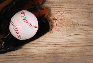 Baseball. Ball in Glove over wood background with copy space.
