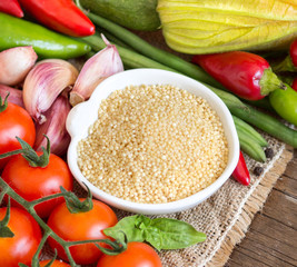 Raw Organic millet in bowl and vegetables