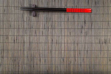 Two chopsticks on sushi mat background