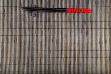 Fotobehang Assortiment Two chopsticks on sushi mat background  © dziewul