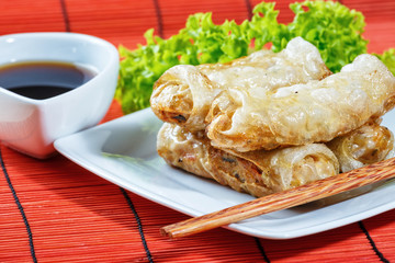 fried spring rolls on red bamboo mat