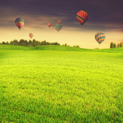 Hot air balloons over green summer meadow, abstract travel backg