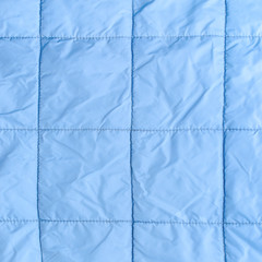  blue silk quilted fabric as a background, closeup