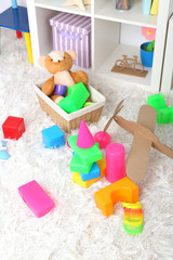 Fototapeta na wymiar Colorful toys on fluffy carpet in children room