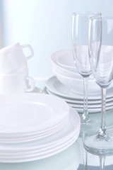 Set of white dishes on table on light background