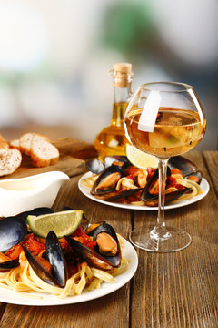 Tasty noodles with mussels on table, close up