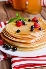 Sweet pancakes with berries on table close-up