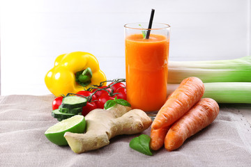 Glass of fresh carrot juice and vegetables on a napkin