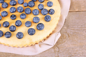 Tasty homemade pie with blueberries on wooden table