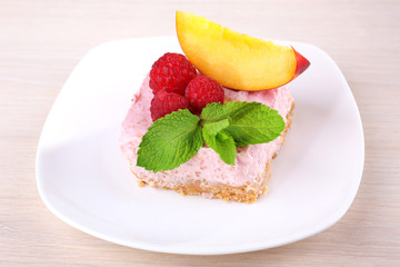 Cake with fruits and berries on plate on wooden background
