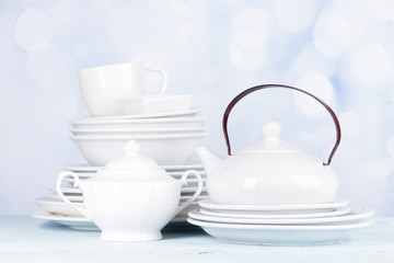 White crockery and kitchen utensils, on light background
