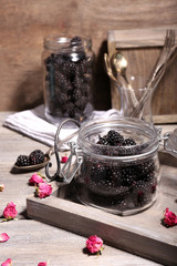 Fototapeta na wymiar Sweet blackberries in glass jar on wooden background