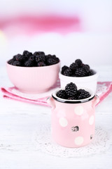 Fototapeta na wymiar Sweet blackberries in color bowl on bright background