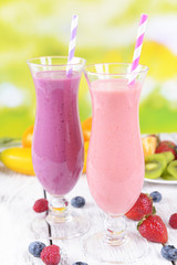 Delicious berry cocktails on table on bright background