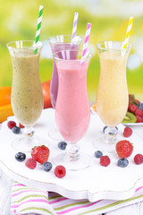Delicious berry cocktails on table on bright background
