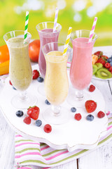 Delicious berry cocktails on table on bright background