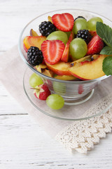 fresh tasty fruit salad on wooden table