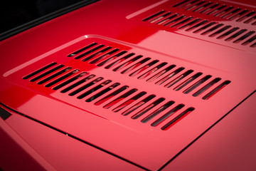 Auto engine grille closeup on a red sport car.