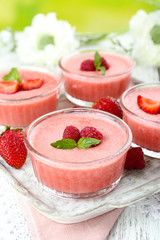 Delicious berry mousse in bowls on table close-up