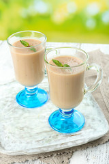 Delicious berry mousse in glasses on table on bright background