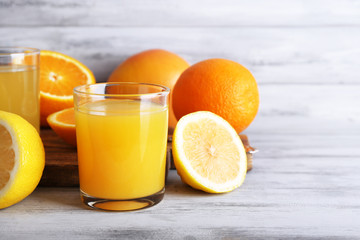 glasses of juice with fresh fruits on grey wooden table