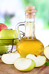 Apple cider vinegar in glass bottle and ripe fresh apples,