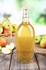 Apple cider vinegar in glass bottle and ripe fresh apples,