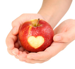 Red apple with heart in hands isolated on white