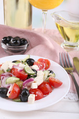 Greek salad served in plate with glass of wine
