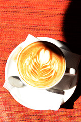 Cup of coffee with cute drawing in cafe