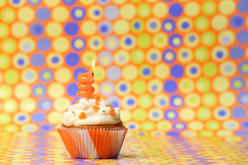 Delicious birthday cupcake on bright background