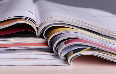 Magazines on wooden table on gray background