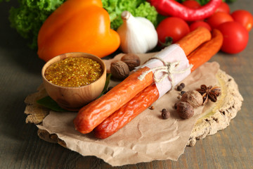 Smoked thin sausages, mustard in bowl and spices