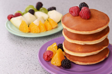 Pancake with fruits and berries on plate on table close up