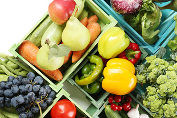 Fresh organic vegetables and fruits in wooden boxes, close up