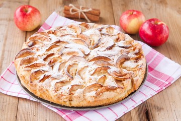 apple pie on a wooden background with cinnamon