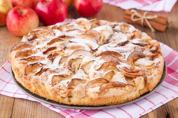 apple pie on a wooden background with cinnamon