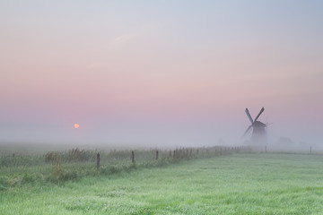 Fototapeta na wymiar windmill and misty sunrise