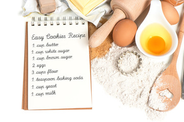 recipe book and baking ingredients eggs, flour, sugar, butter, y