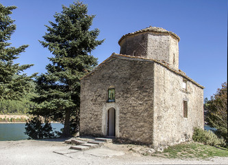 Fototapeta na wymiar Greek small ancient chapel on a mountainous lake