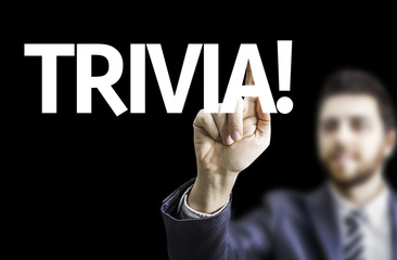Business man pointing to black board with text: Trivia