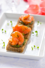 Delicious appetizer canapes of black bread with smoked salmon