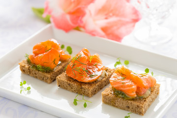 Delicious appetizer canapes of black bread with smoked salmon