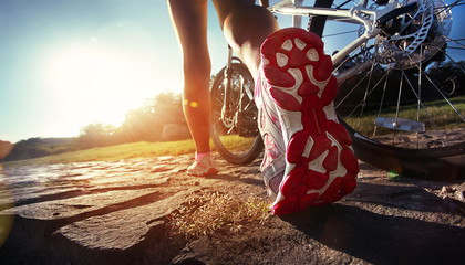 Fototapeta premium Athlete woman is running with her extreme mountain bike outdoors