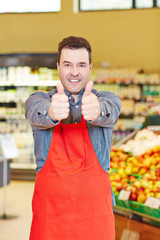 Verkäufer hält Daumen hoch im Supermarkt